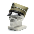 Genuine Polish military officer peaked cap with eagle insignia, beige fabric, black visor, and leather chin strap on display stand.