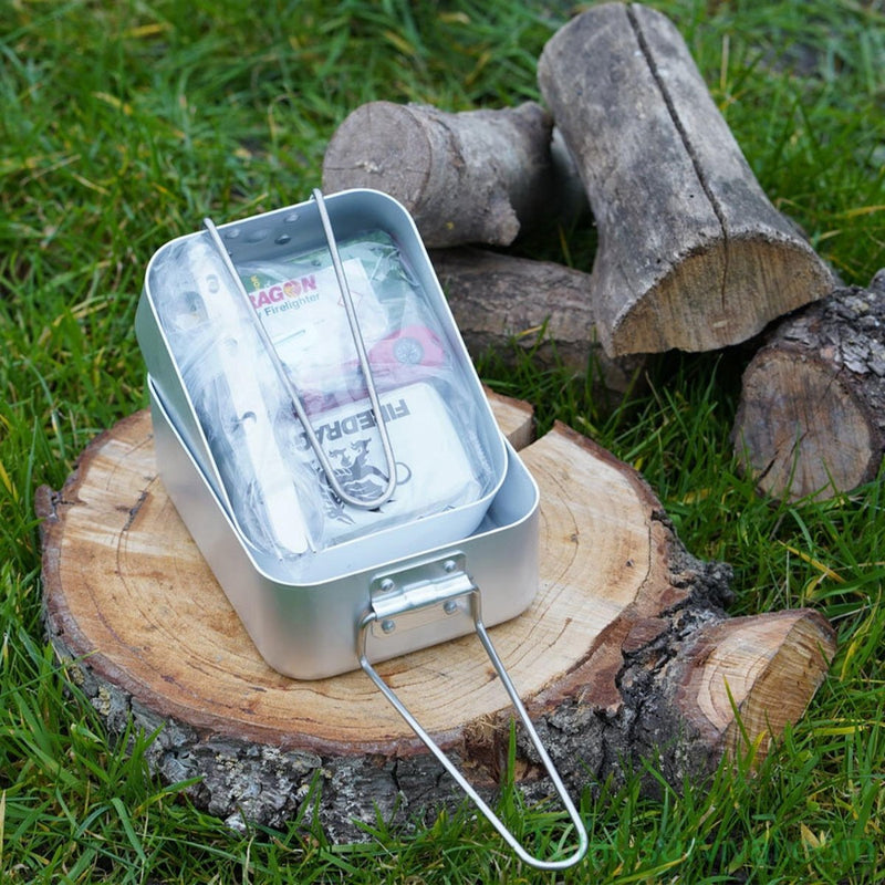 BCB Outdoor hiking cooking set with mess tins, cutlery, fire striker, and can opener on a tree stump outdoors