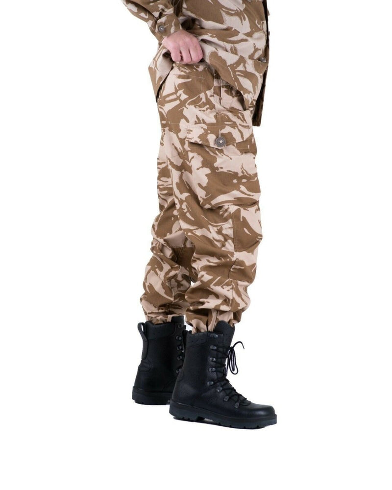 Side view of genuine British army desert camouflage combat trousers with cargo pockets and black military boots