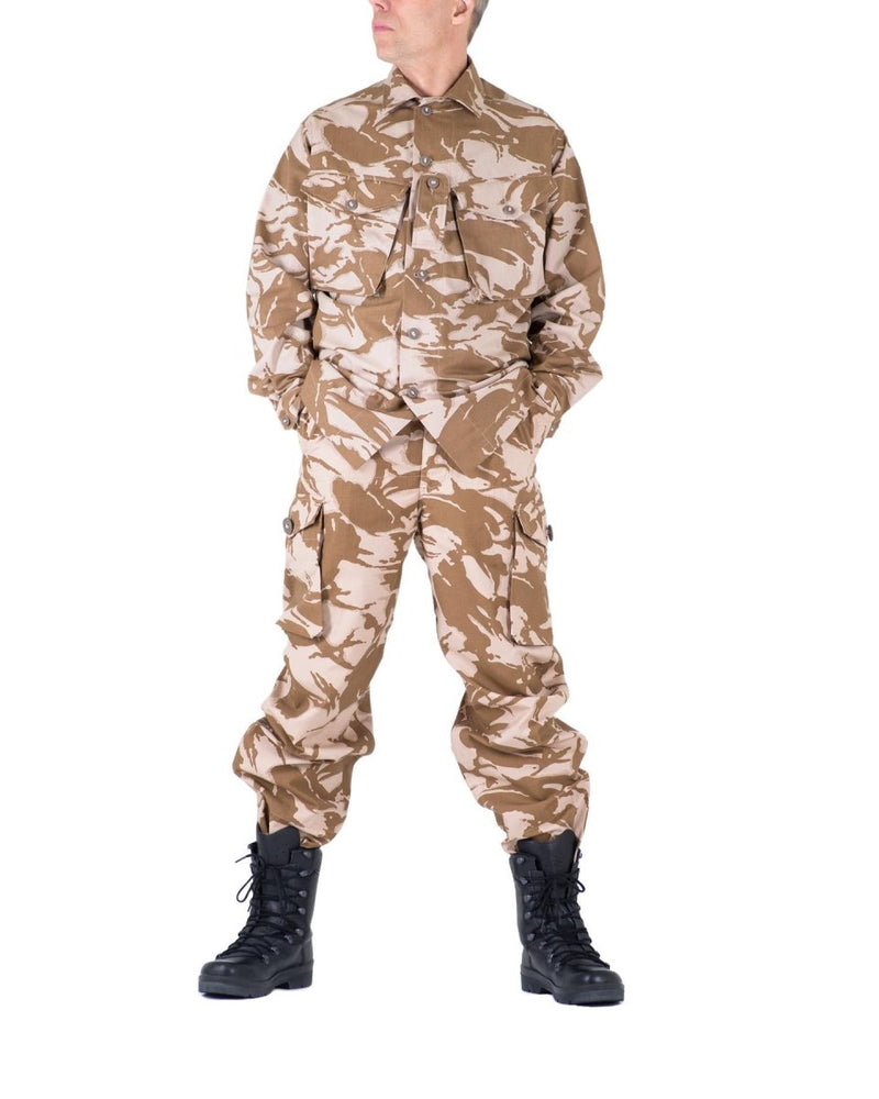Man wearing genuine British army desert camouflage combat trousers and jacket with black military boots
