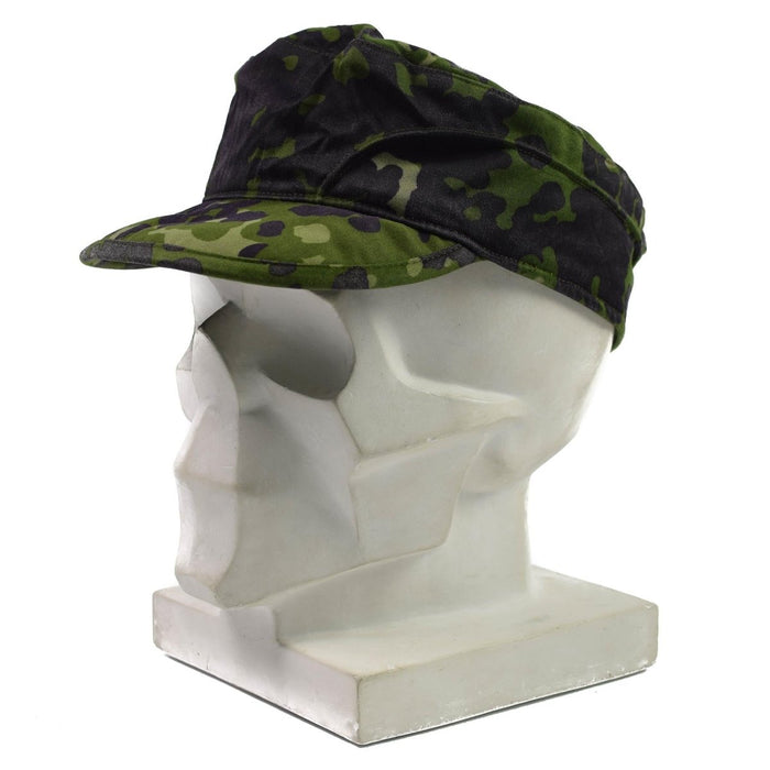 Echte veldpet van het Deense leger in M84 Flecktarn-camouflage met klep, ontworpen voor comfort en bescherming tegen de zon.