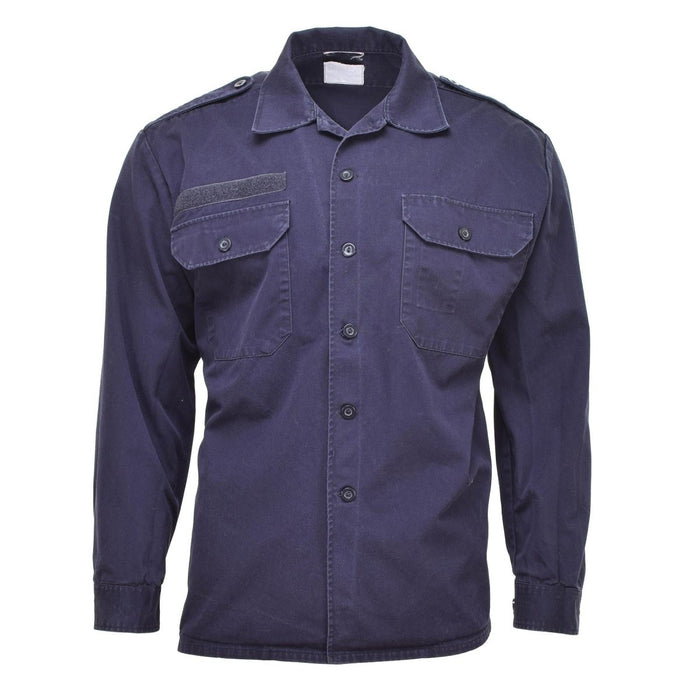 Marineblauw Nederlands legeroverhemd met lange mouwen, zakken met knopen, manchetten en schouderepauletten. Militaire overschotjas.