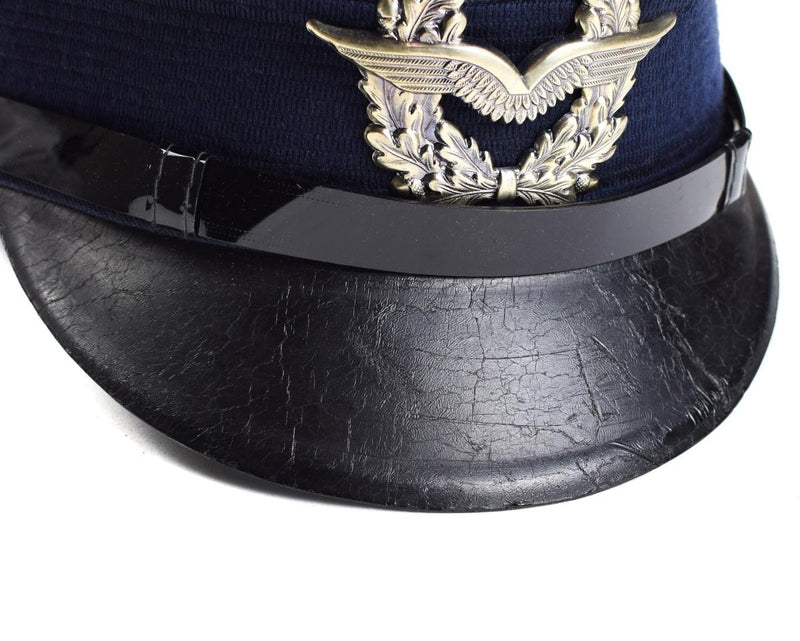 Vintage German Luftwaffe Air Forces peaked visor cap with blue wool body and detailed metal insignia on front
