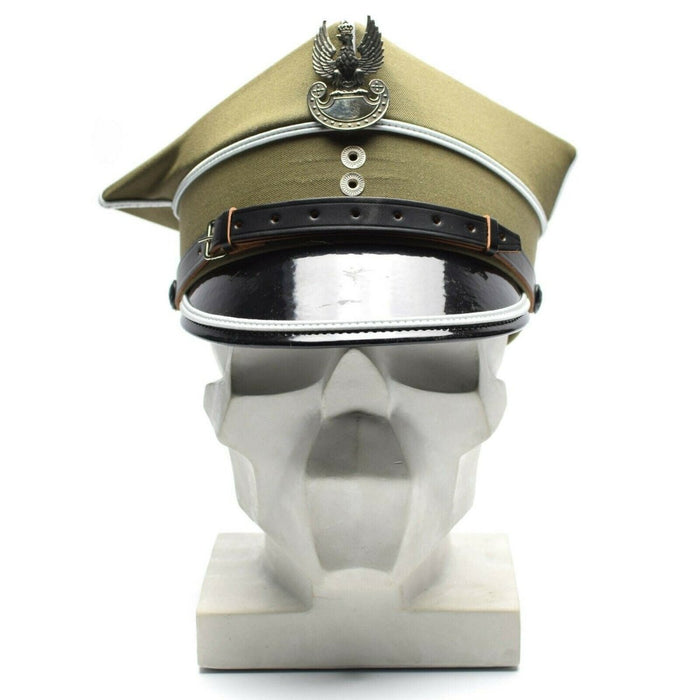 Echte Poolse militaire officierspet met adelaarskokarde en leren vizier weergegeven op het hoofd van de witte mannequin.