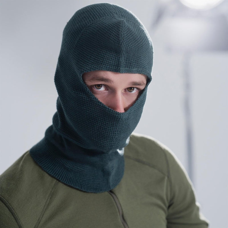 Man wearing a genuine Swiss Army grey knitted balaclava, covering head and neck, designed for winter outdoor use.
