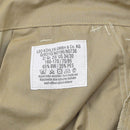 Close-up of care label on Leo Kohler Commando tactical field pants in Tropentarn camo showing fabric details and washing instructions.