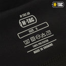 Close-up of M-TAC black balaclava label showing size small, fabric care symbols, 100% polyester, made in Ukraine.