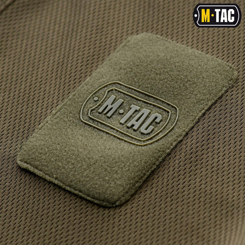 Close-up of breathable olive fabric with M-TAC military style patch on a lightweight tactical polo shirt