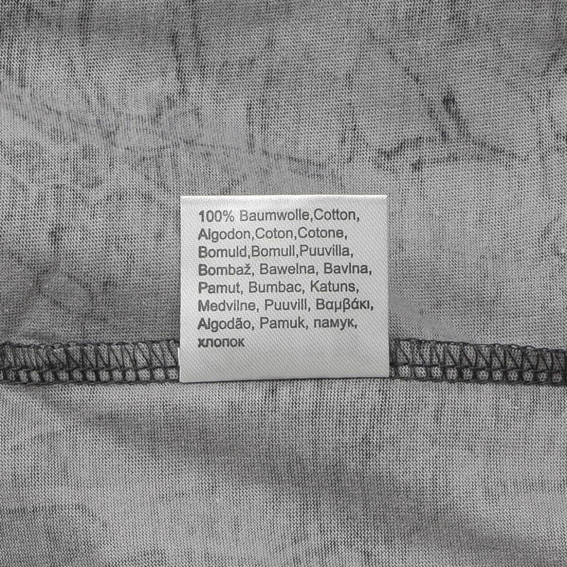 Close-up of a gray fabric label showing 100% cotton material in multiple languages on a camouflage T-shirt interior.
