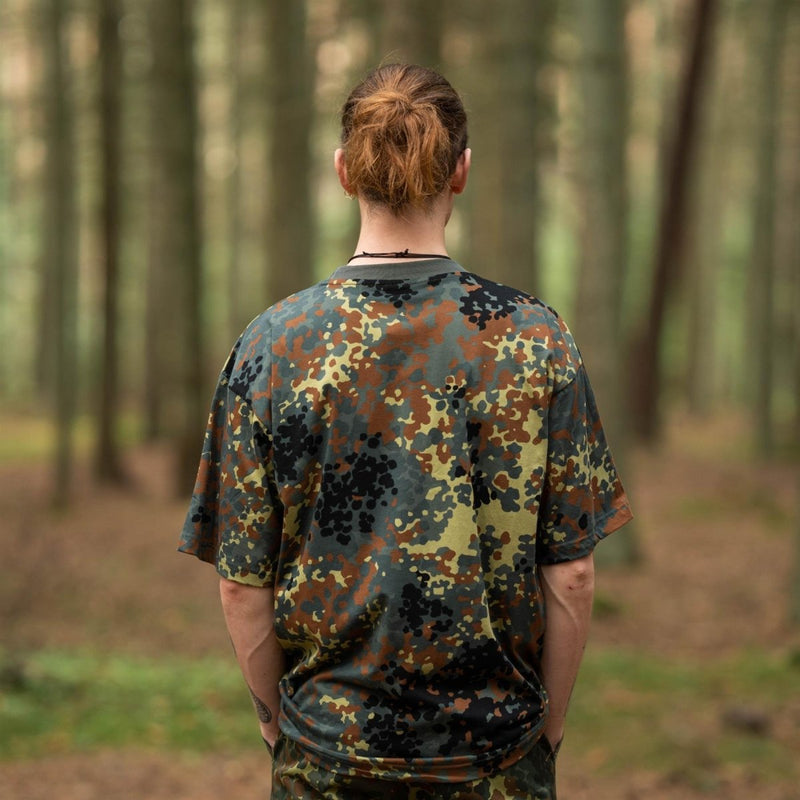 Rear view of person wearing MFH U.S. military-style BW camouflage lightweight breathable sportswear T-shirt in forest.