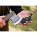 Hands holding MORAKNIV lightweight axe with boron steel blade and leather sheath outdoors in natural light