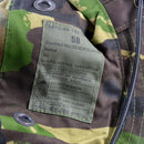 Close-up of British Army boonie cap label showing size, material composition, and detailed care instructions on woodland camo fabric.