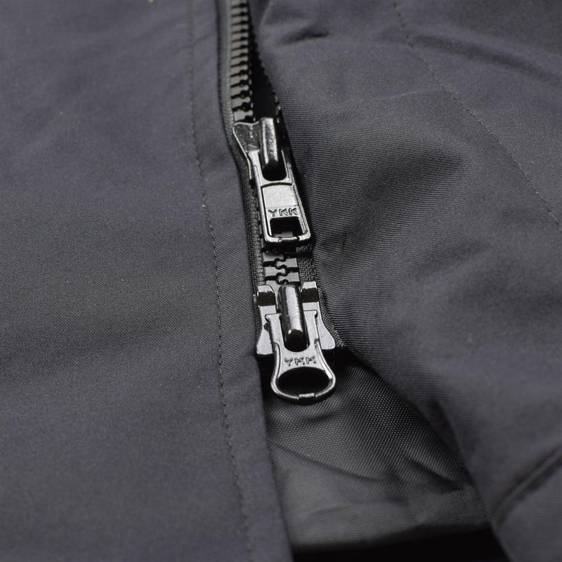 Close-up of a durable black waterproof YKK zipper on a British military rain jacket’s front closure.