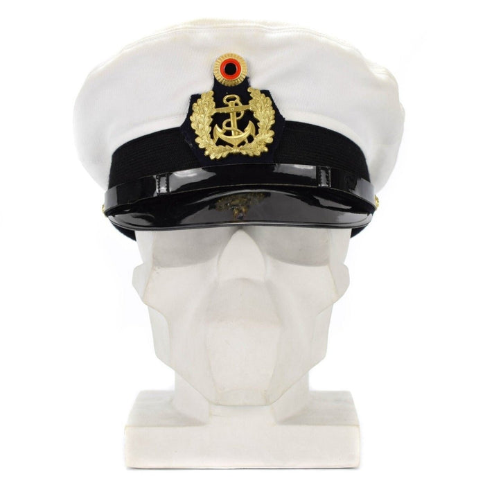 Witte pet van de Duitse marineofficier met gouden insignes en zwarte klep, weergegeven op het hoofd van een witte mannequin.