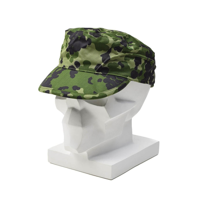 Originele Deense militaire M84 camouflageveldpet met opvouwbare oorflappen, afgebeeld op een wit mannequinhoofd.