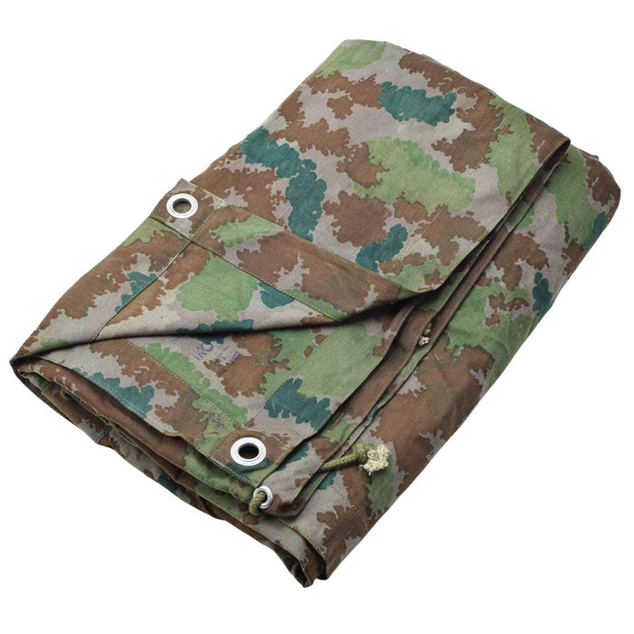 Gevouwen vintage Duitse militaire camouflageponchotent met metalen doorvoertules voor gebruik op de camping of in een overlevingsschuilplaats