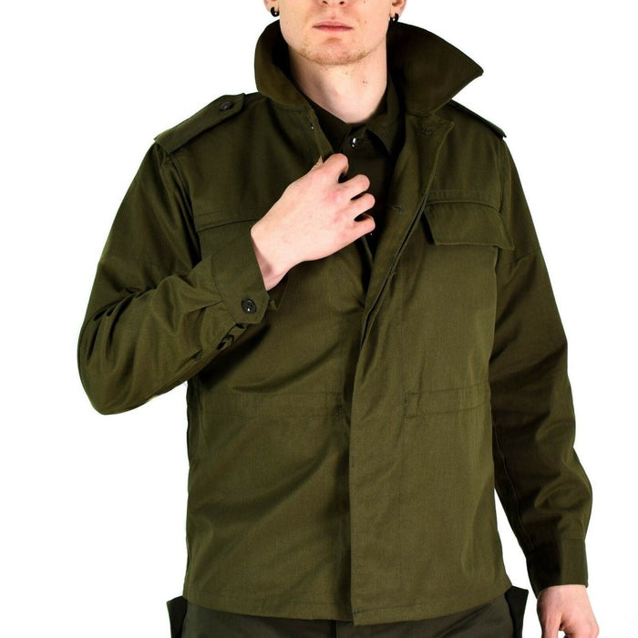 Man met een origineel vintage Tsjechisch M85 olijfgroen militair veldjack met manchetten met knopen en epauletten