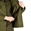 Person showing the inner side of an olive green vintage Czech M85 army field jacket with button-up cuffs and chest pocket